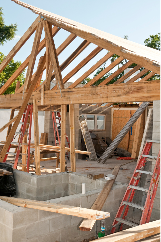 A house is being built with wooden beams and ladders.