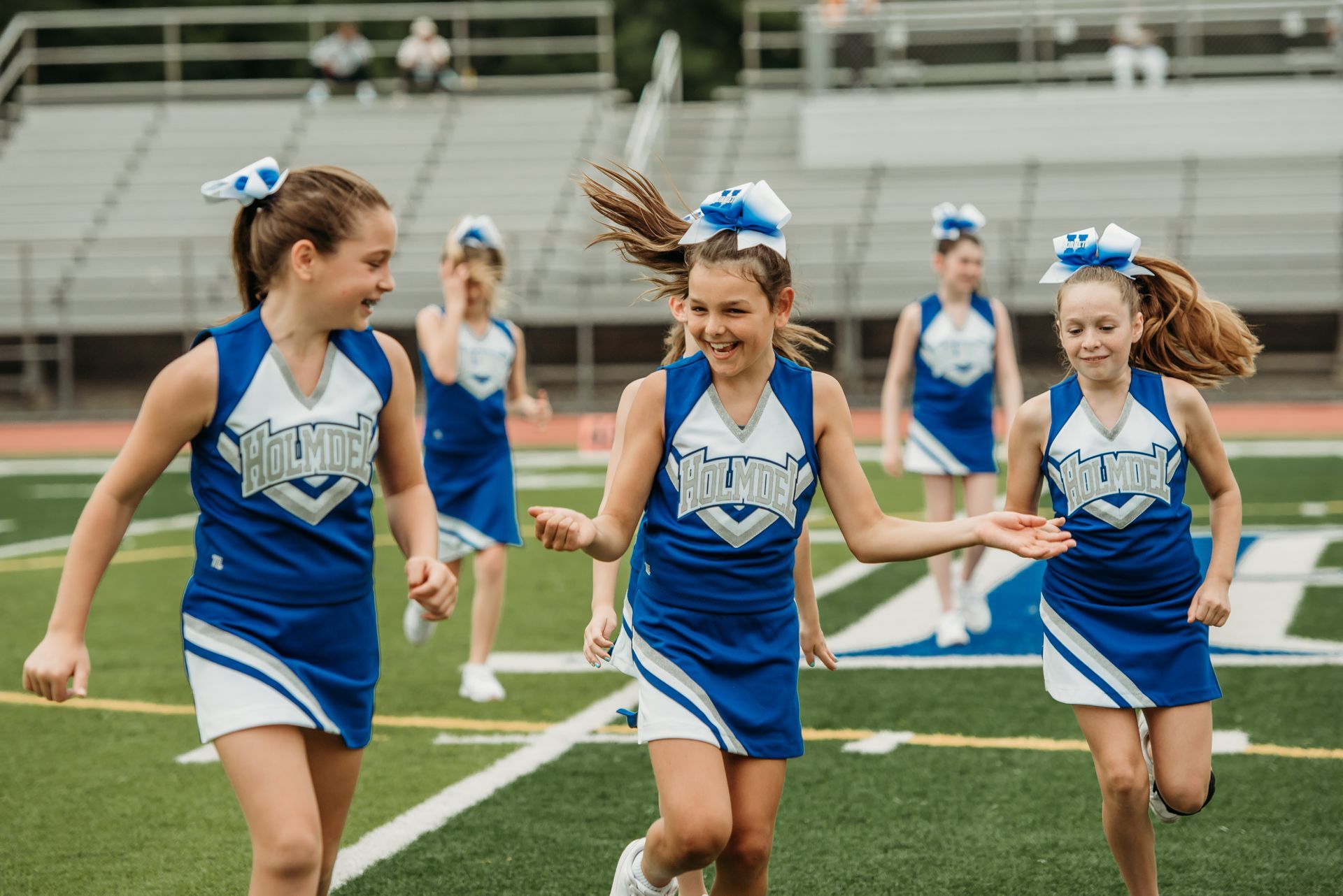 Red, white, and blue pom-poms held high by cheerleaders during a performance.