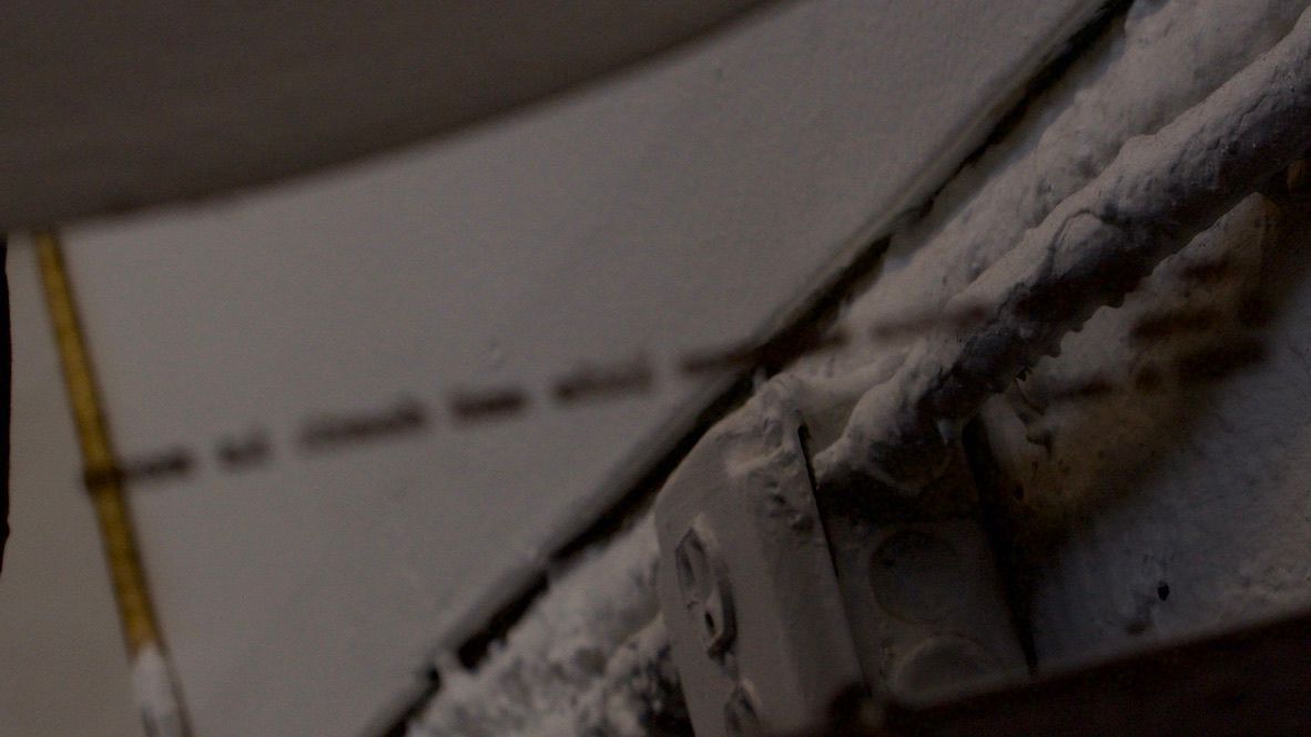 illegible text reflects through a mirror. 