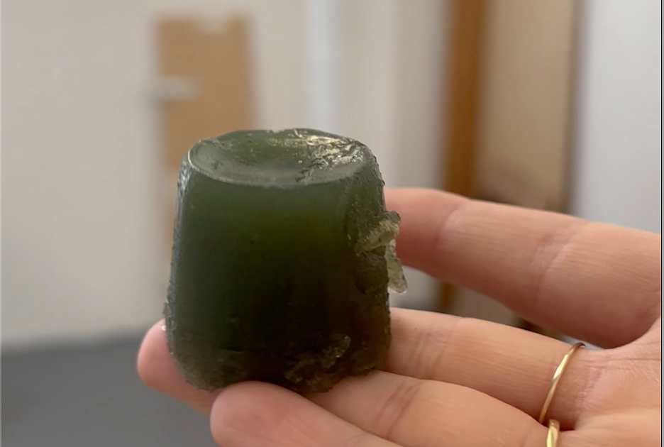a small portion of green jelly resting on the artist's hand