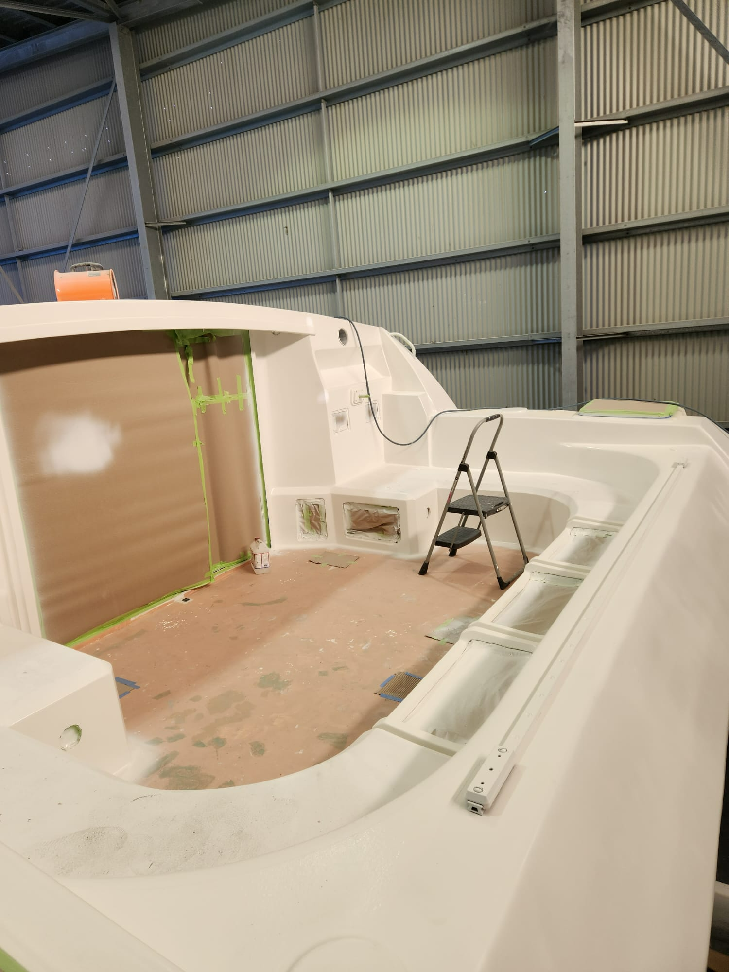 A White Boat is Being Painted in a Warehouse — Baran Yachting in Coomera, QLD