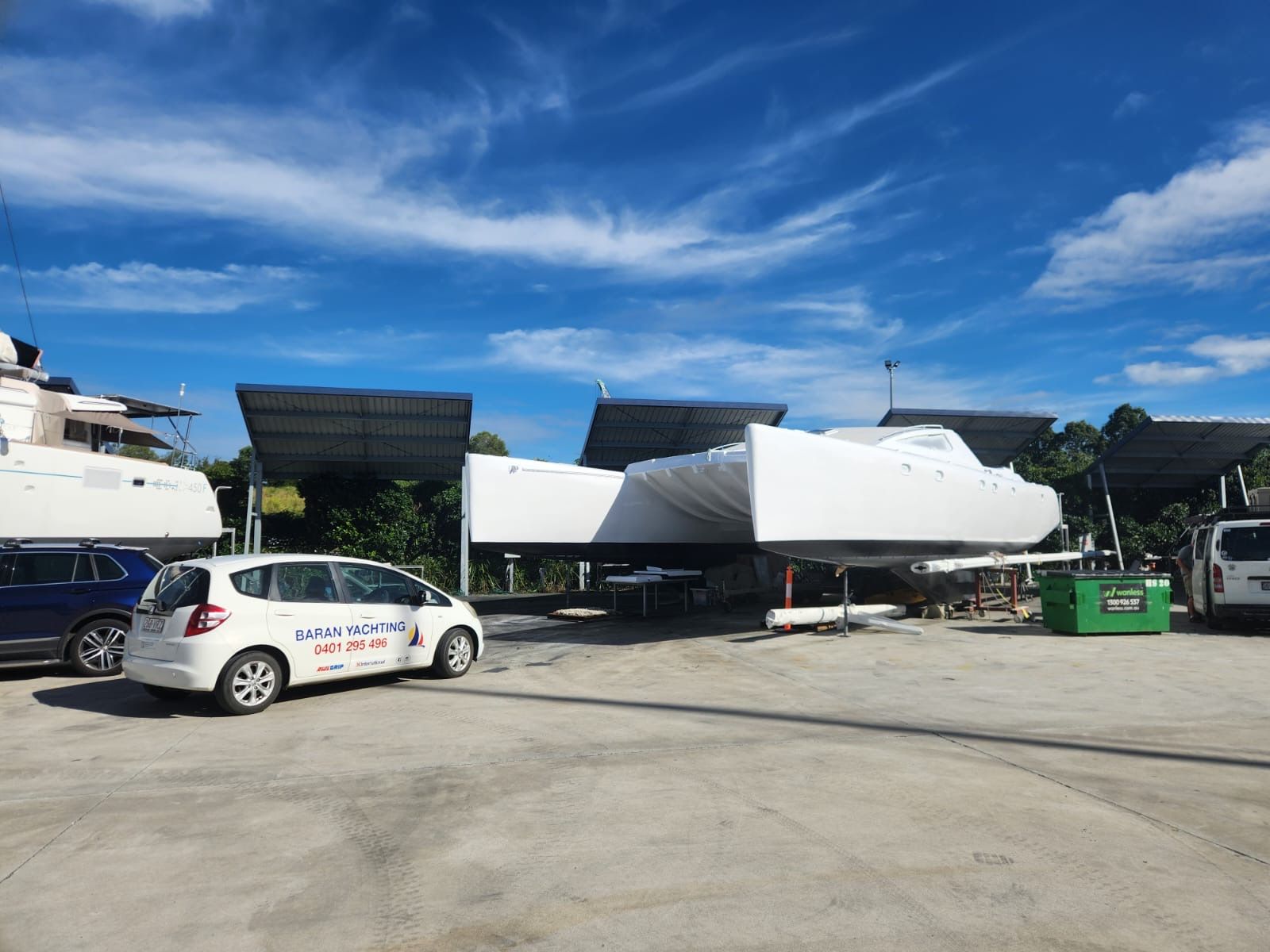A White Car is Parked in a Parking Lot Next to a Boat — Baran Yachting in Coomera, QLD