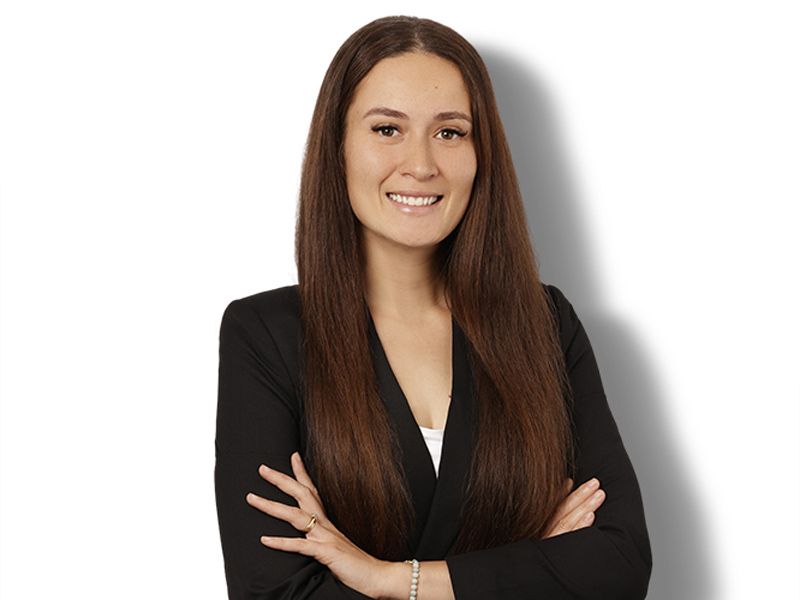 A woman with long brown hair is smiling for the camera.