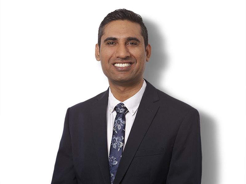 A man in a suit and tie is smiling for the camera.