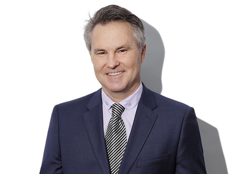 A man in a suit and tie is smiling for the camera.