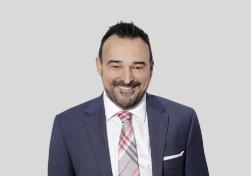 A man in a suit and tie is smiling for the camera.