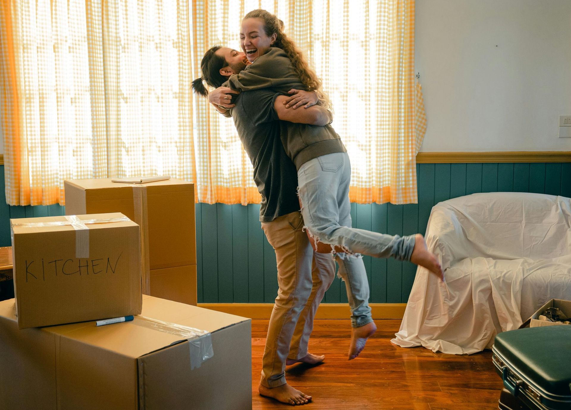 hugging couple while house packing: Logan brokers help homebuyers with conditional loan approval.