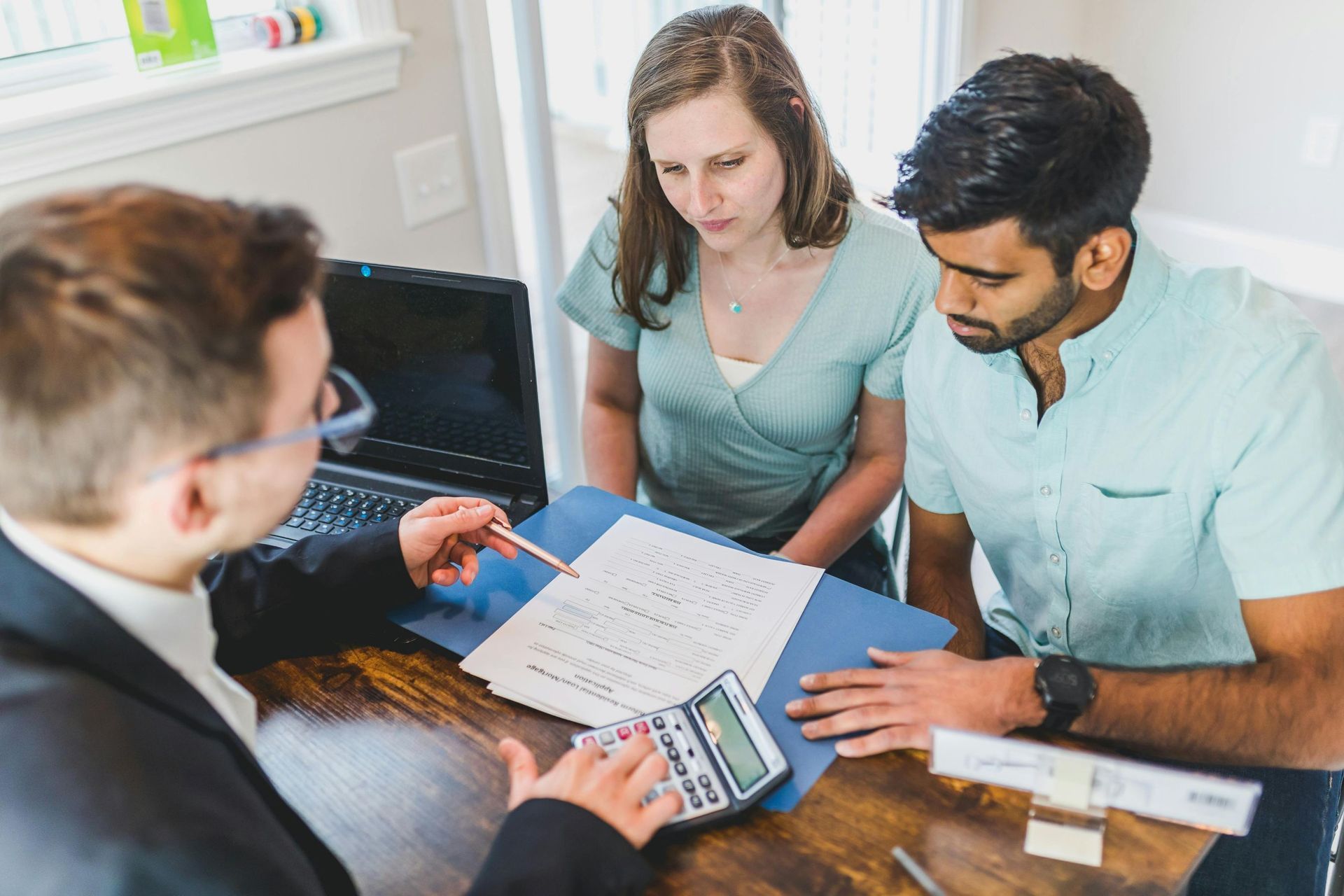 couple talking with broker: Logan mortgage brokers help homeowners with home loan refinancing.
