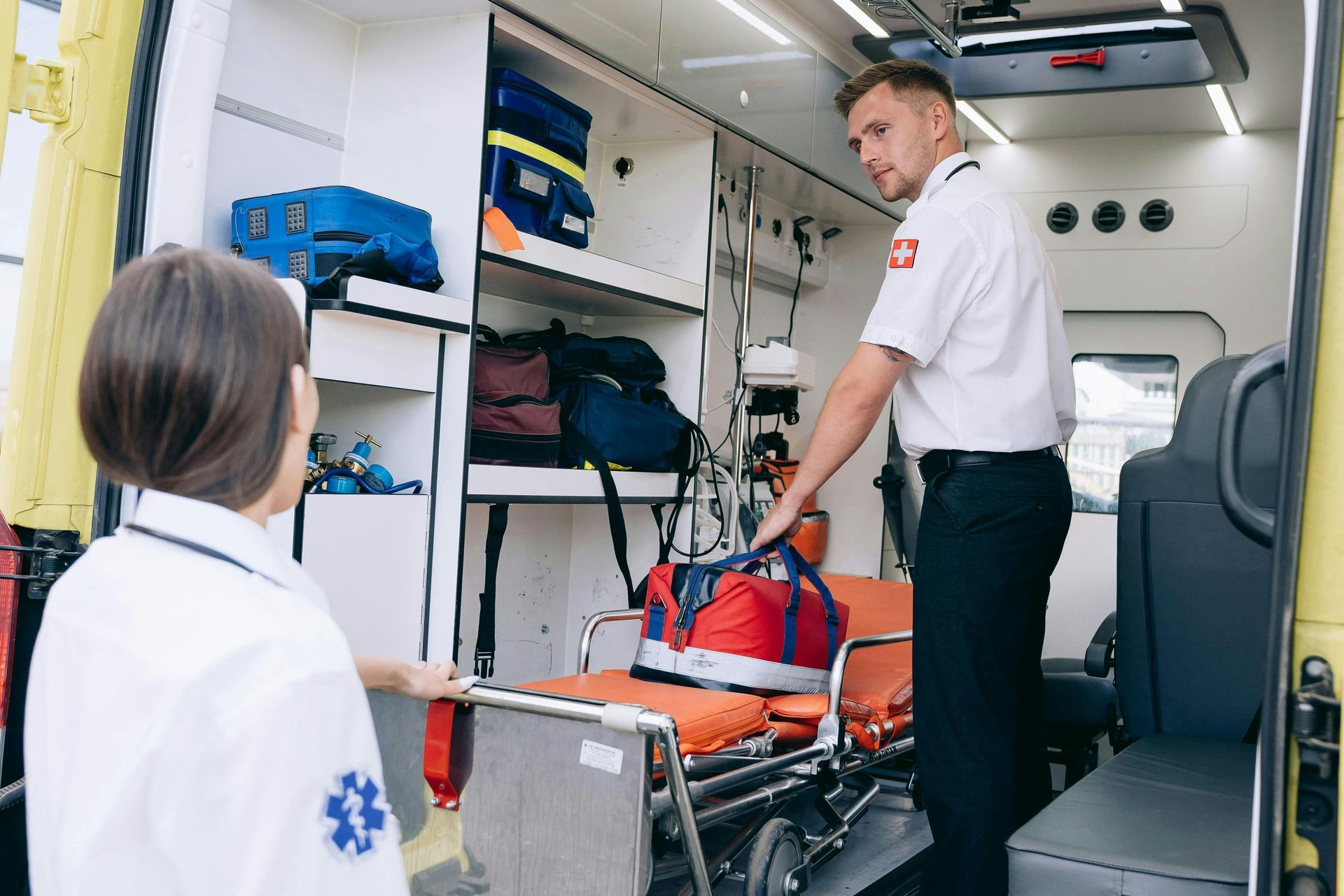a male and female paramedic talking inside an ambulance