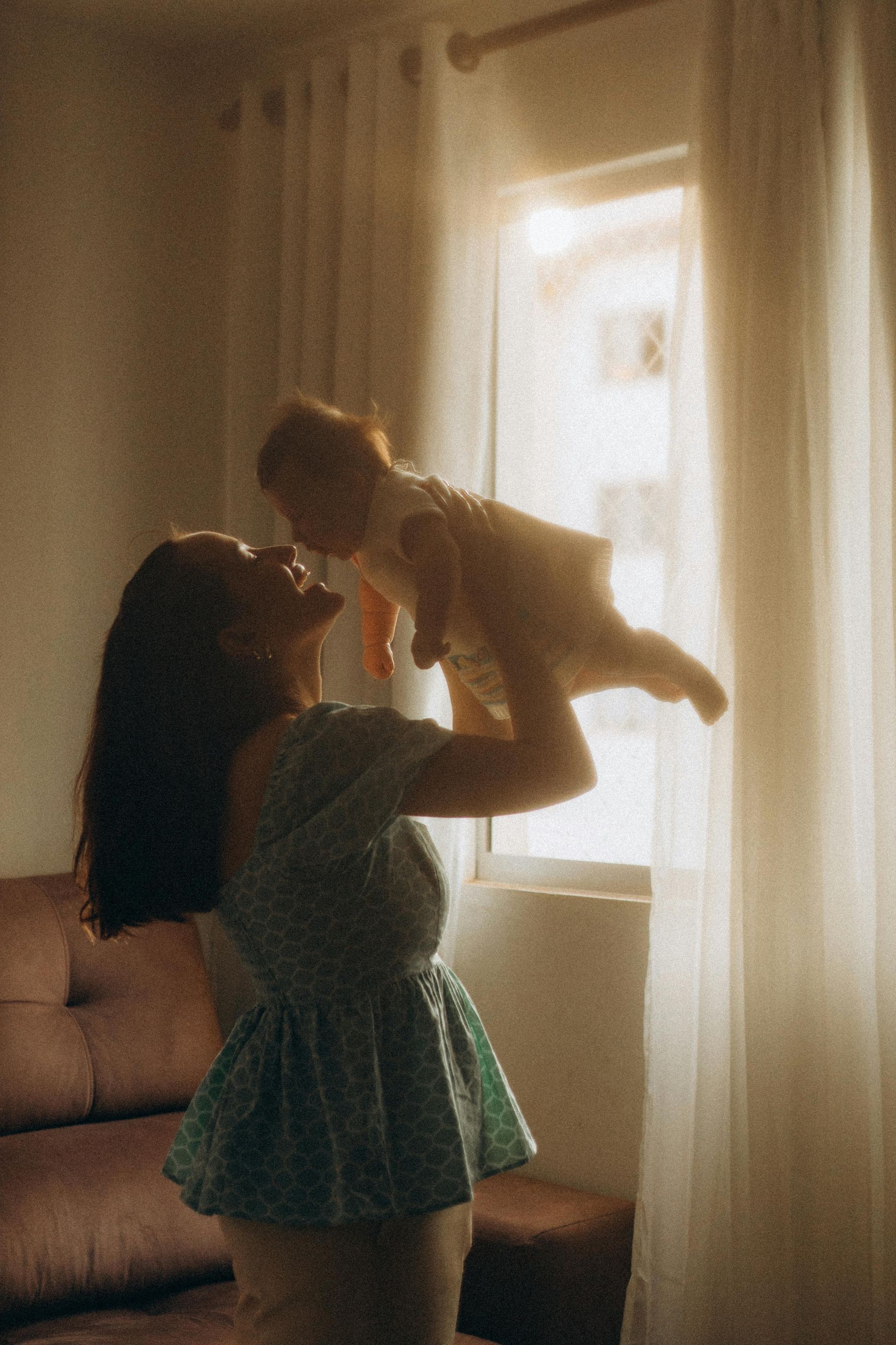A mother holding up a baby.