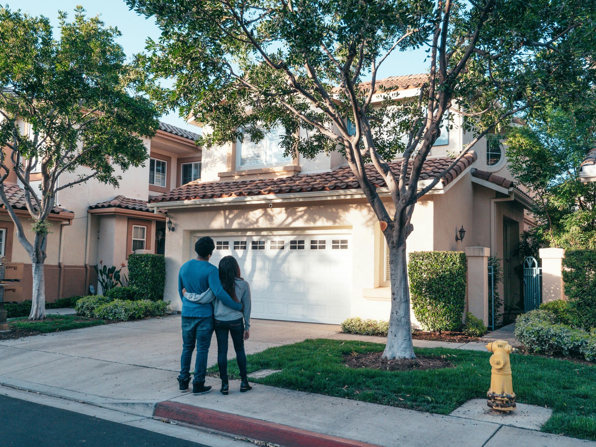 A couple standing in front of a house.

