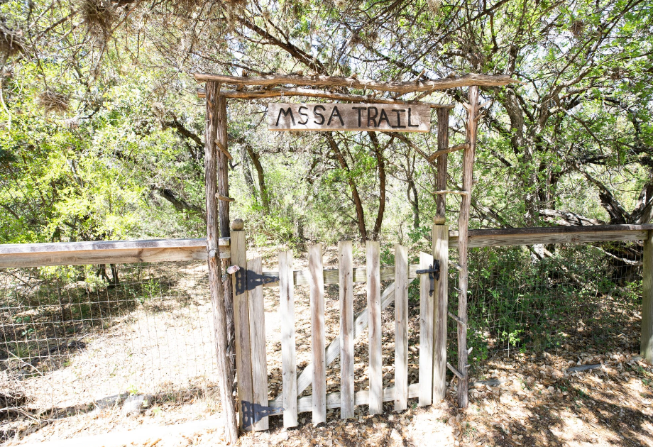 Wooden gate marking the entrance to the Mesa Trail, with sign above.