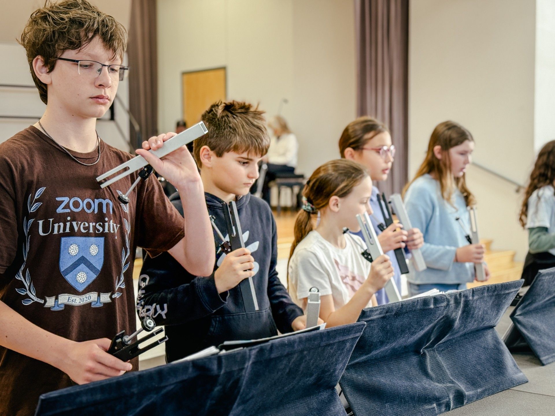 Two children performing with instruments at a concert. Girl with long hair, boy with a white shirt.