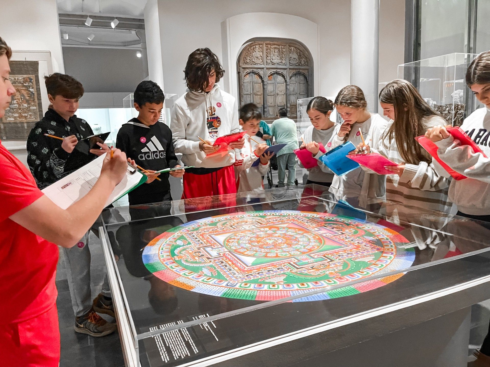 Middle School students gathered around art at the San Antonio Museum of Art, taking notes.