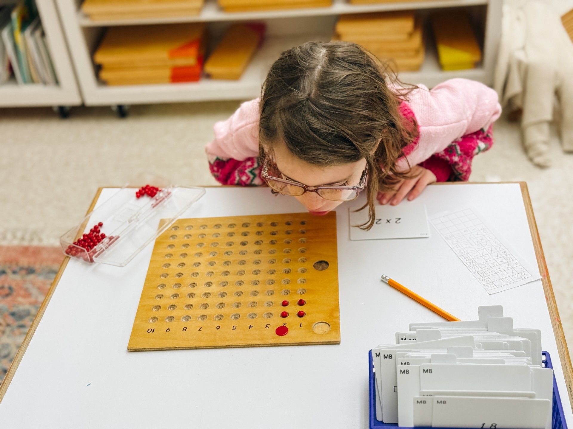 Primary child using a bead board to explore multiplication by 2.