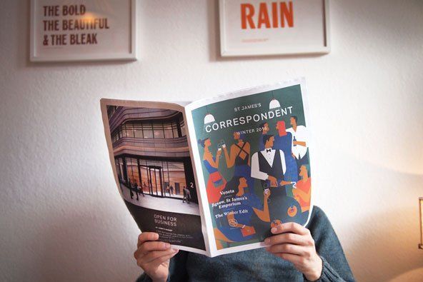 A person is reading a magazine in front of their face.