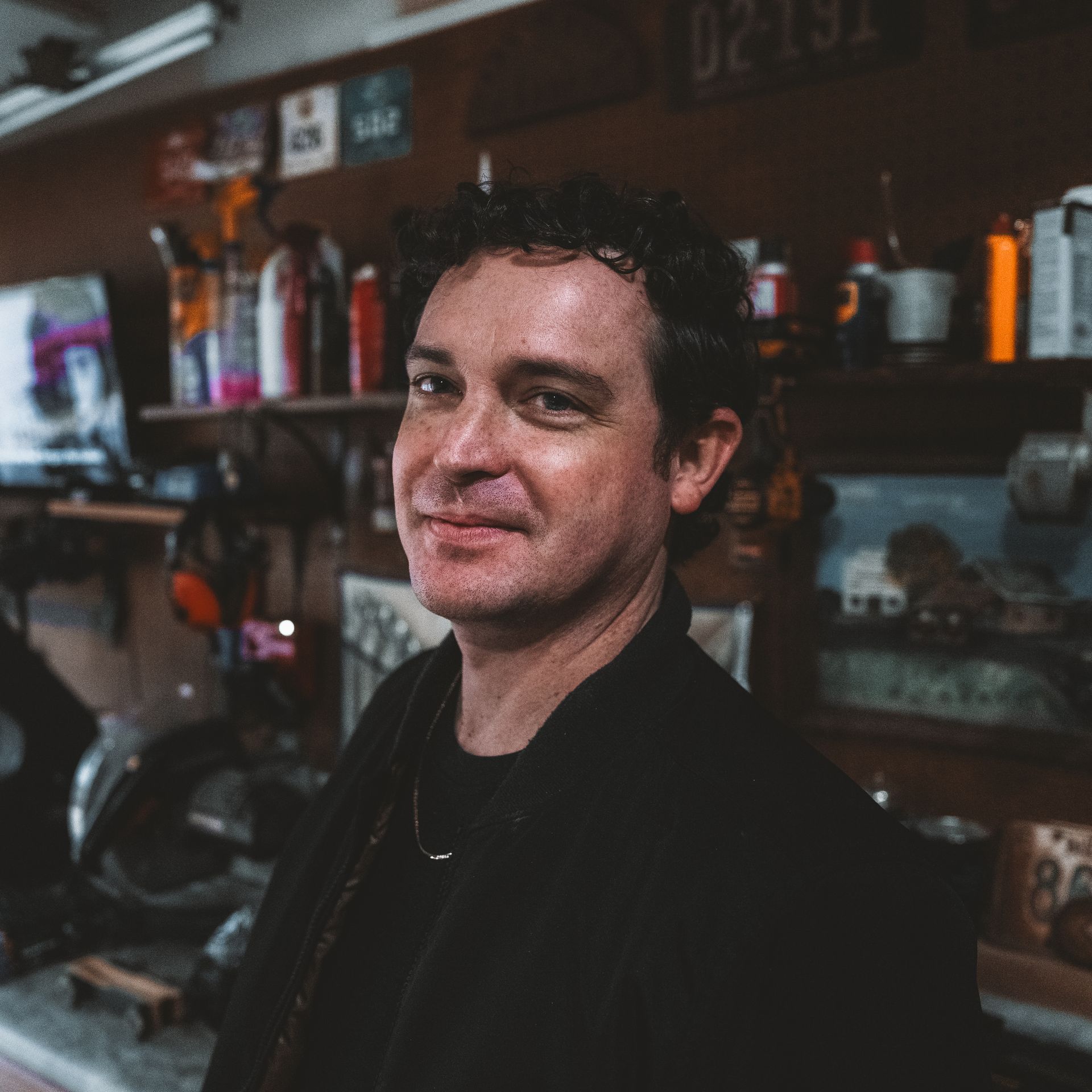 A black and white photo of a man in a garage.