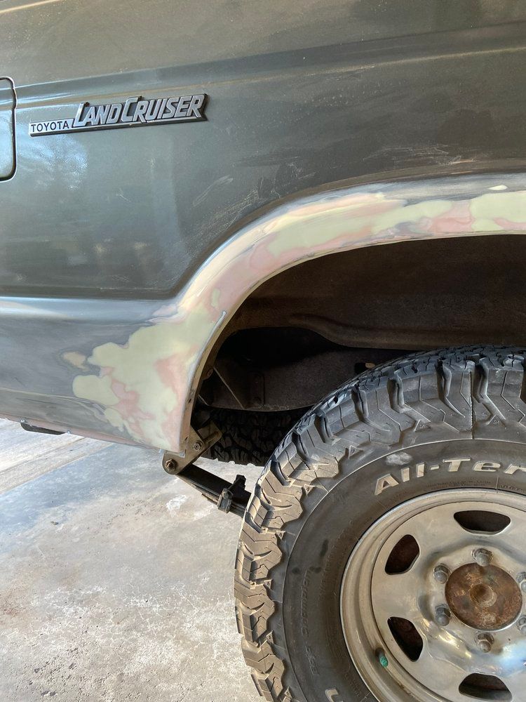 A close up of the fender and tire of a land cruiser.