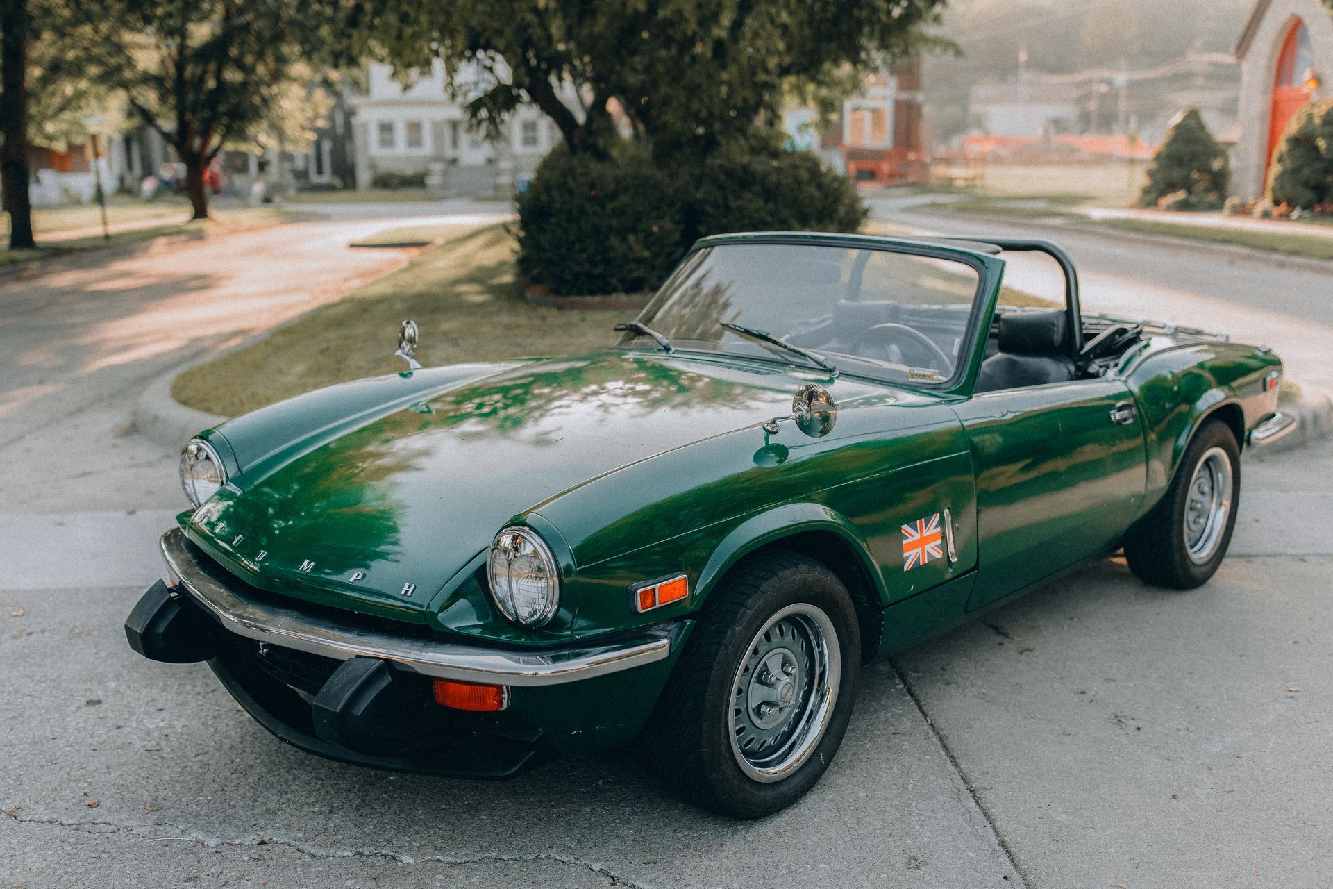 A green sports car is parked on the side of the road.