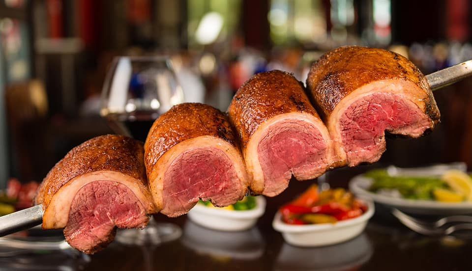 A close up of a piece of meat on a skewer on a table.