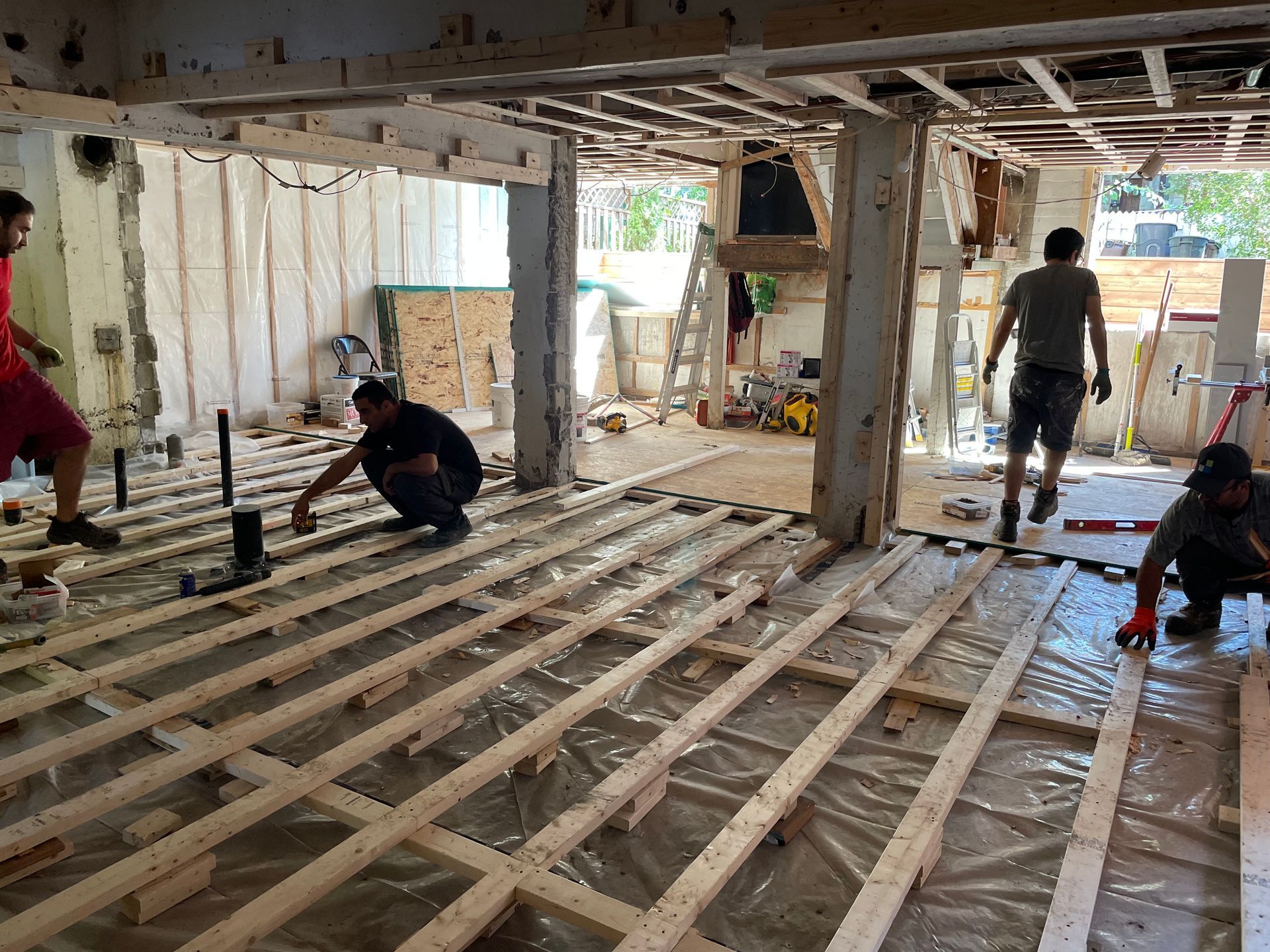 Un groupe d'hommes travaille sur un plancher en bois.