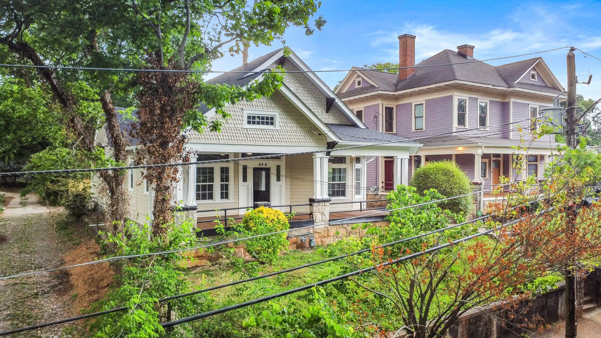 A large house is surrounded by trees and barbed wire.
