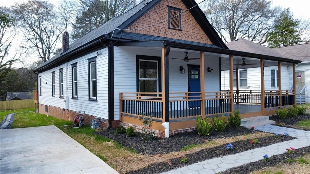 A white house with a blue door and a porch.