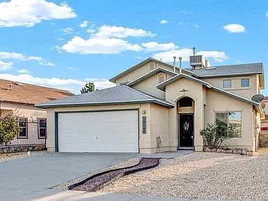 A large house with a white garage door is for sale.- Click to go to