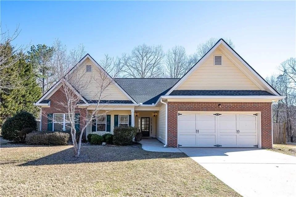 A house with a white garage door and a brick roof