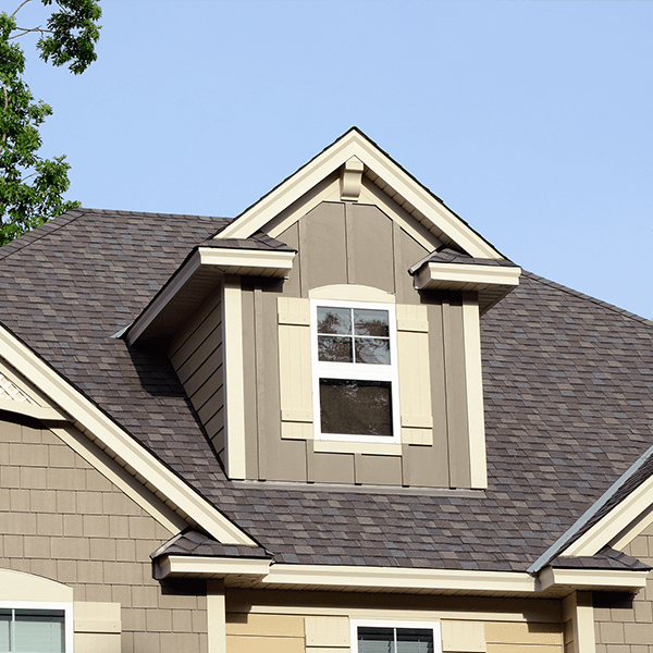 The front of a house with a circular window and columns