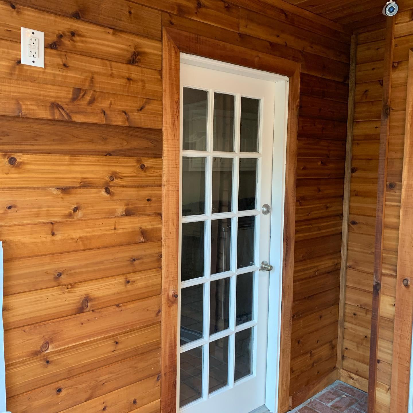 A wooden wall with a white door in the middle of it.