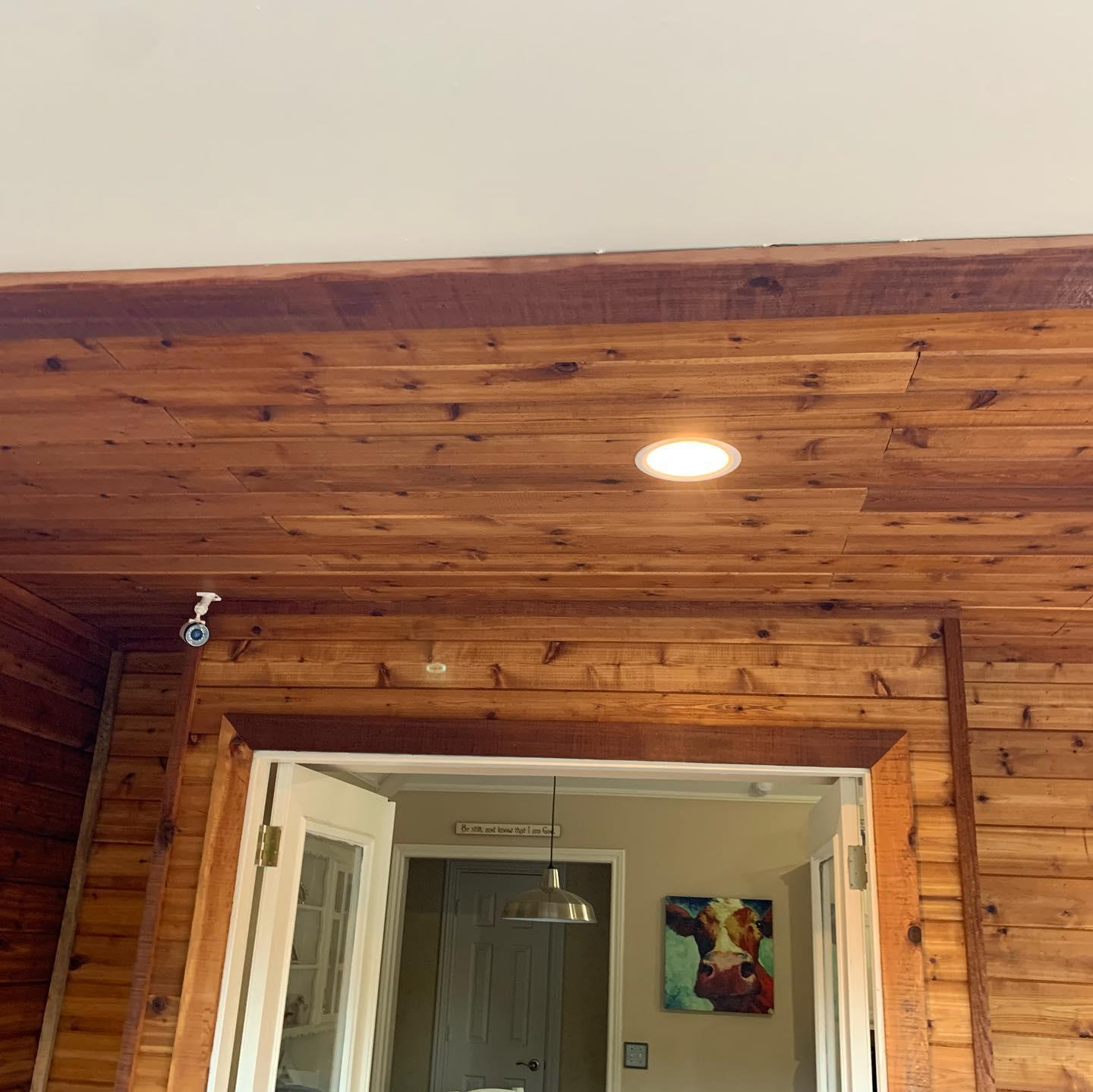 A room with a wooden ceiling and a painting on the wall.