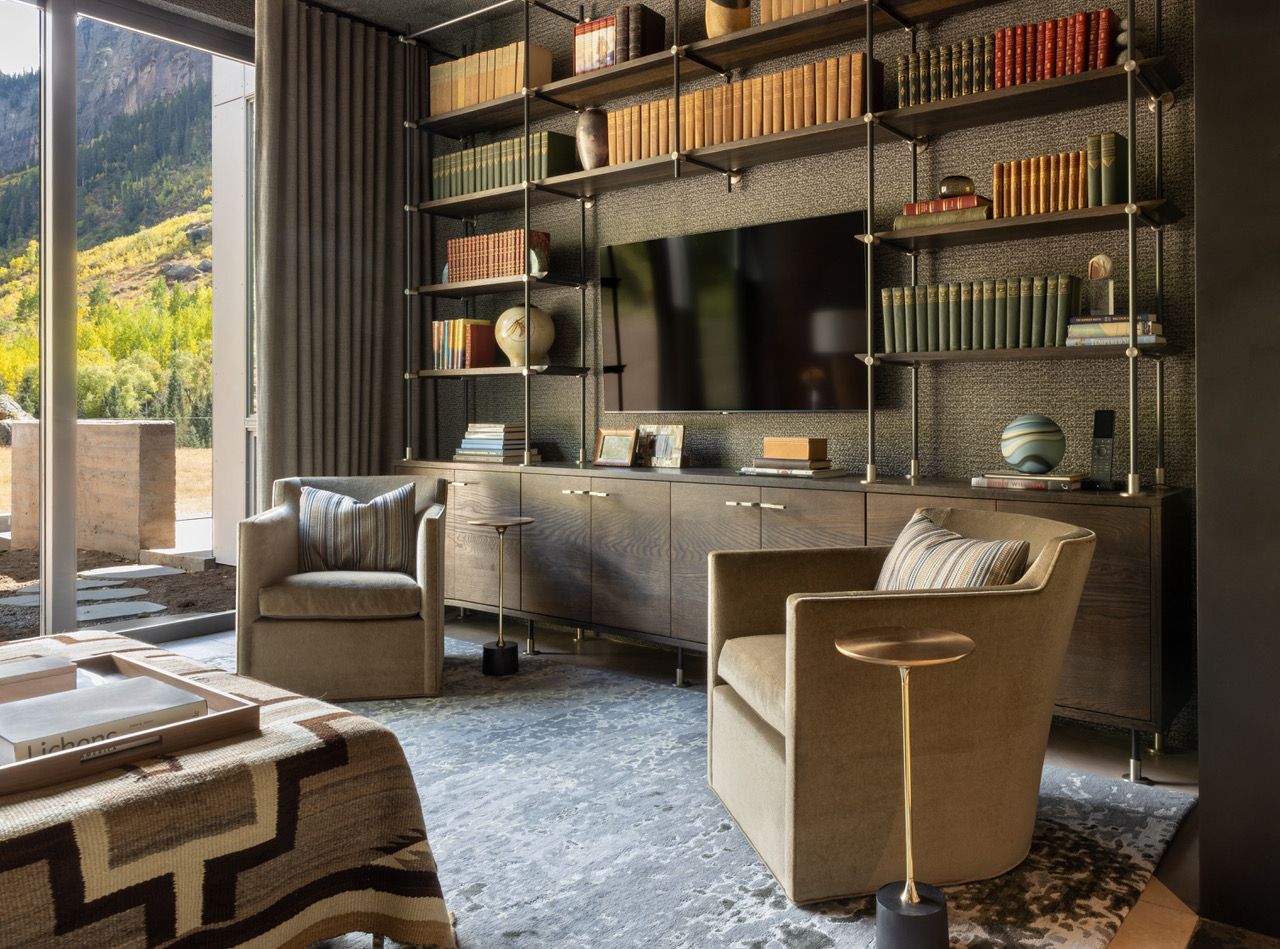 A living room filled with furniture and a flat screen tv and tan blackout drapes