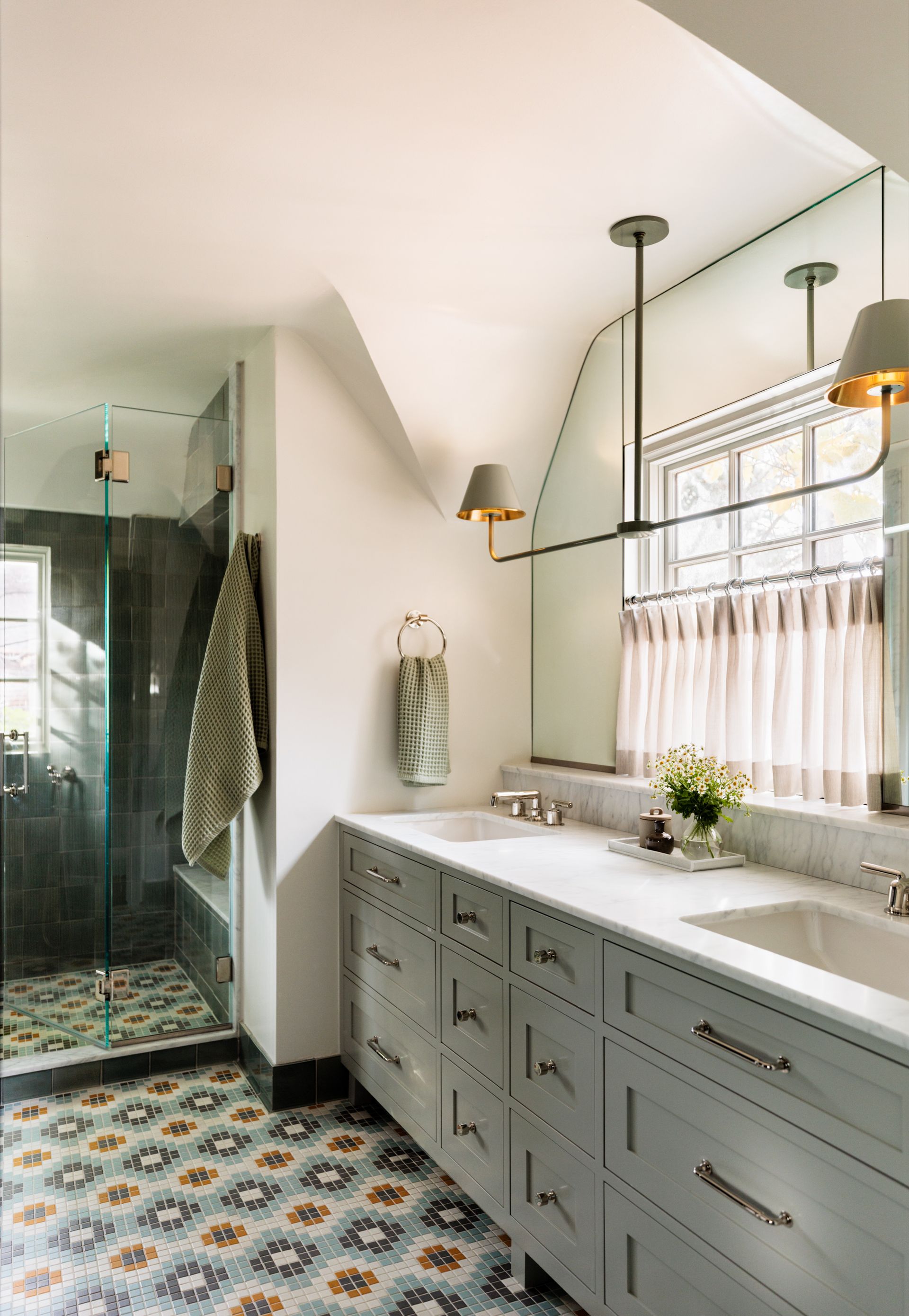A bathroom with two sinks and a walk in shower.