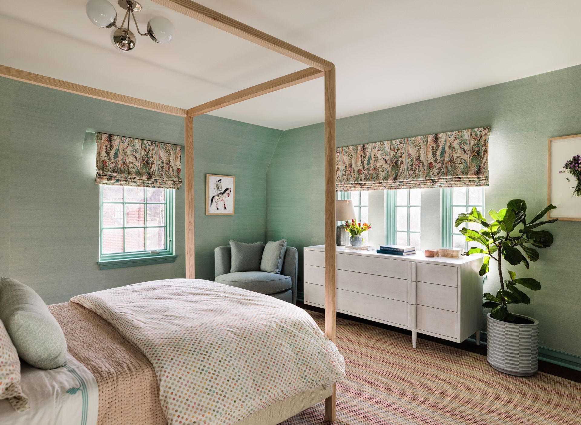A bedroom with a canopy bed , dresser , chair and window.