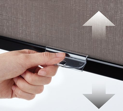 A close up of a person 's hand pulling on a handle on a blind