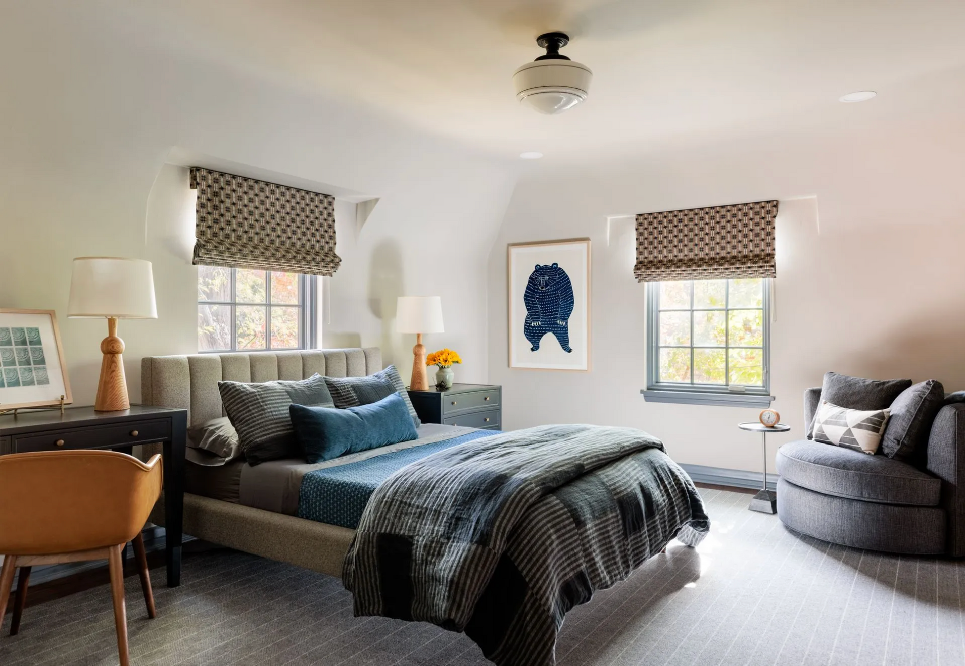 Roman shades in a bedroom with a large bed in the middle of the room.