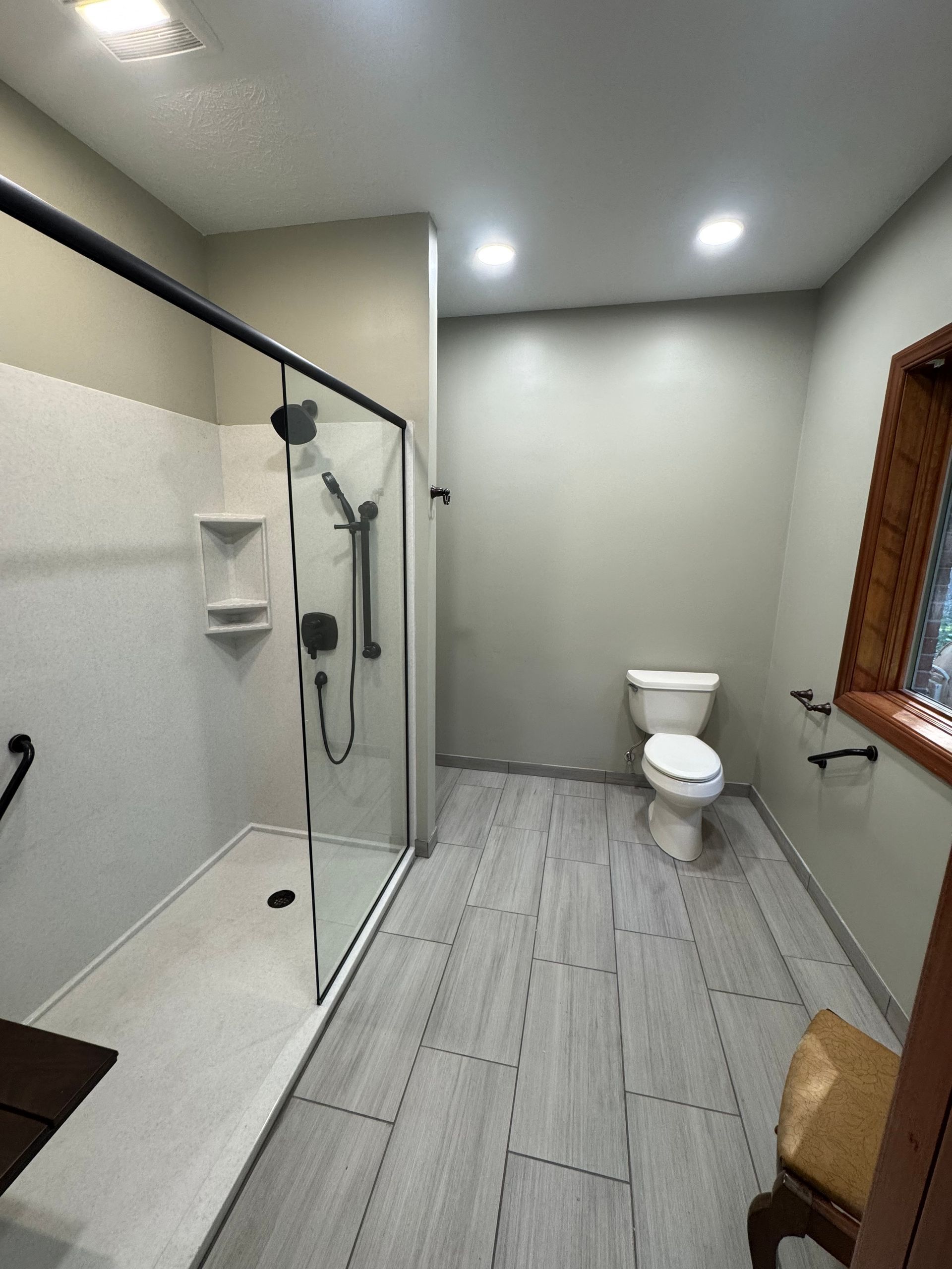 Bathroom with white vanity, blue wall, and wood-look flooring. Includes toilet, tub, and black fixtures.