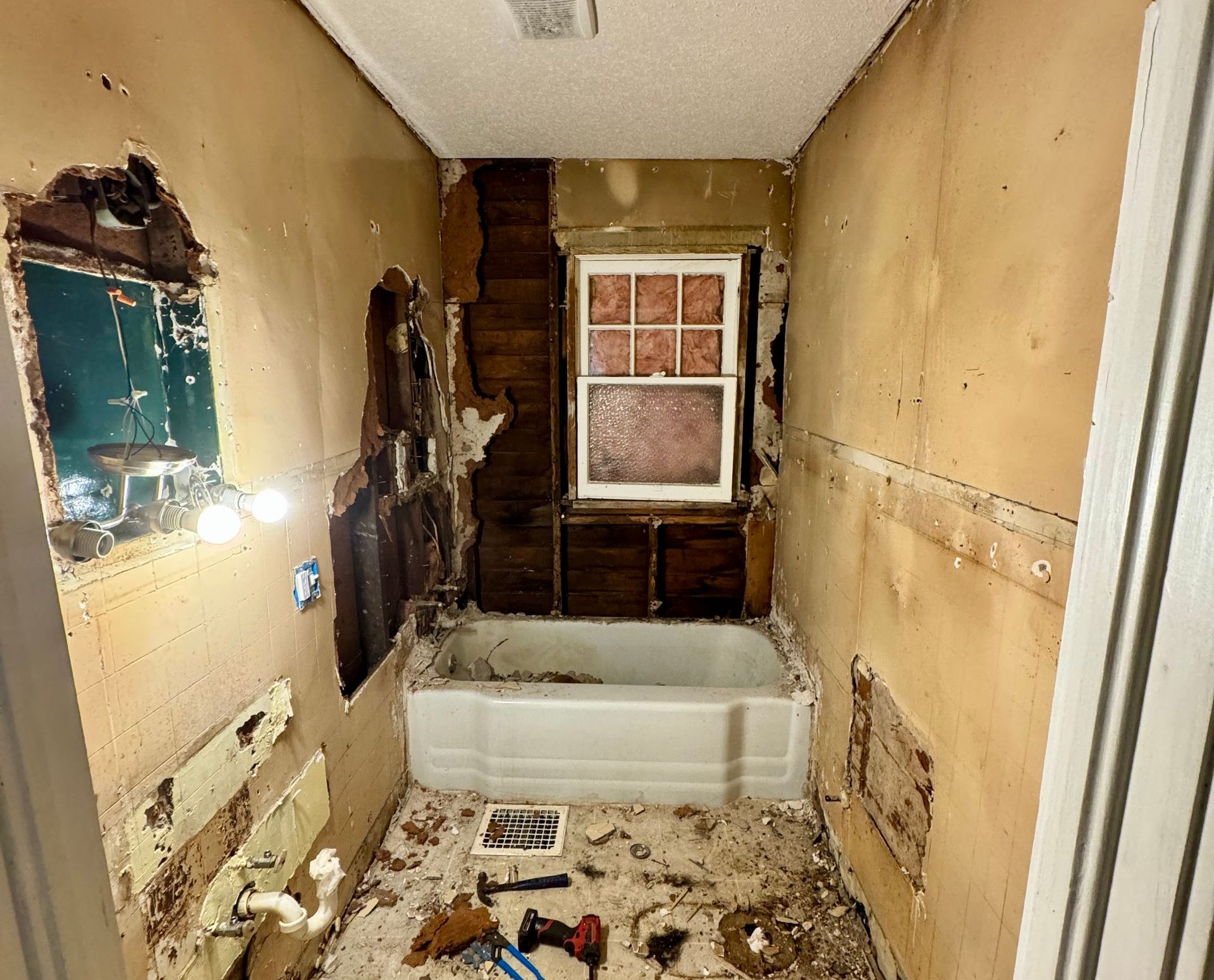 A bathroom with a bathtub and a window is being remodeled.