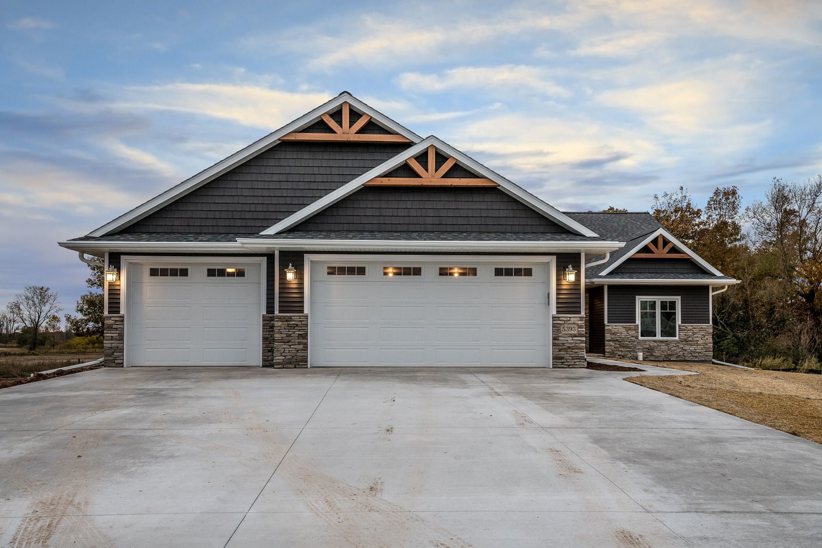 A house with three garage doors and a concrete driveway
