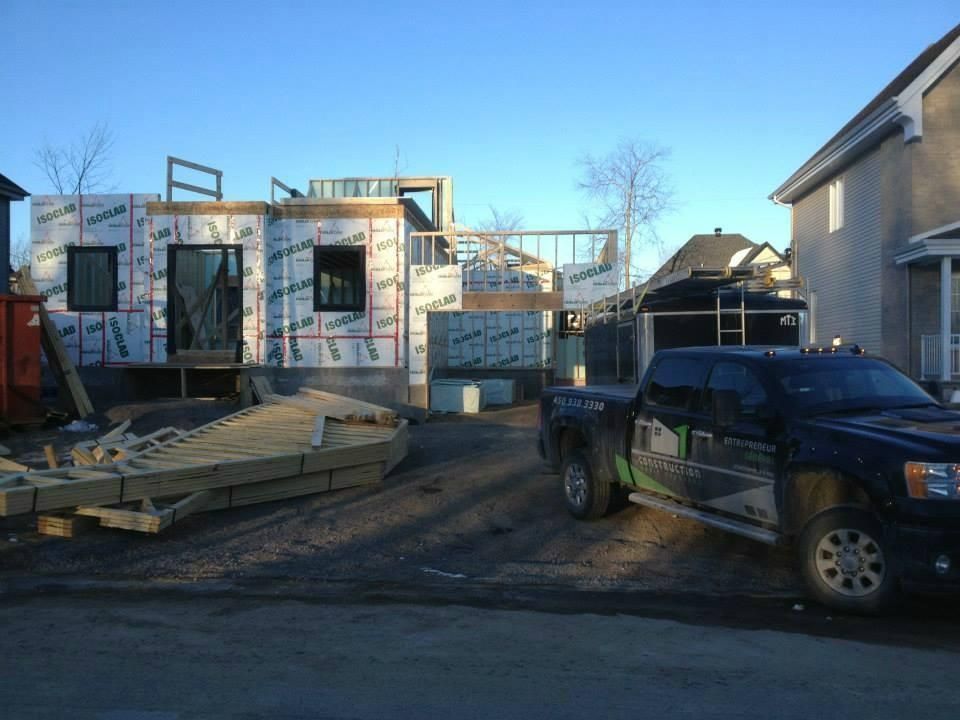 Un camion est garé devant une maison en construction.