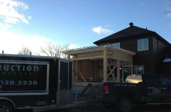 Un camion de construction est garé devant une maison en construction