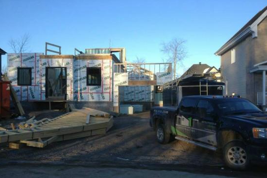 Un camion est garé devant une maison en construction.
