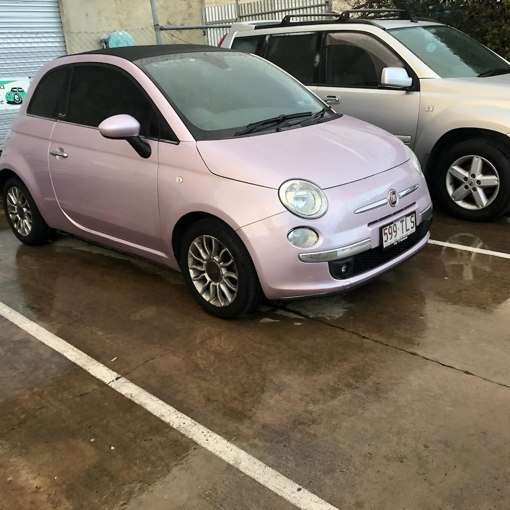 A Pink Car is Parked Next to a Silver Suv — Kawana Auto Service In Warana, QLD