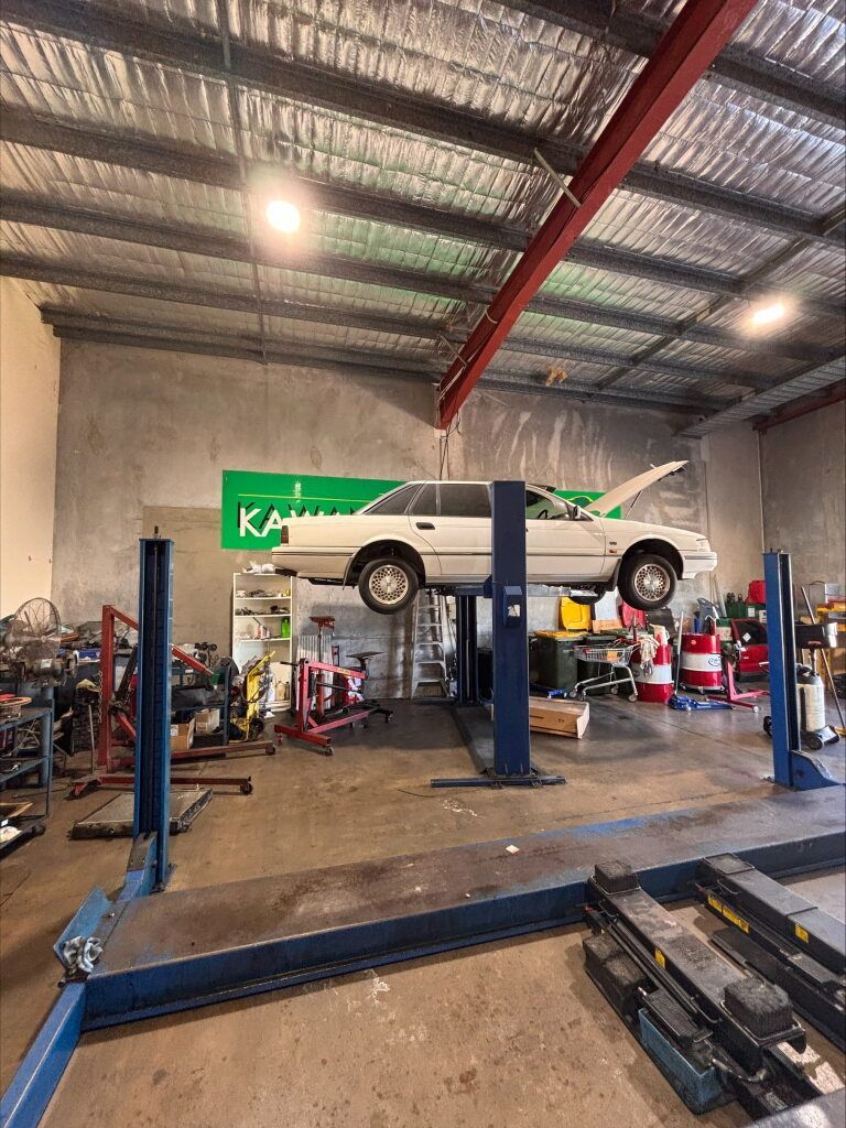 A White Car On A Hoist — Kawana Auto Service In Warana, QLD
