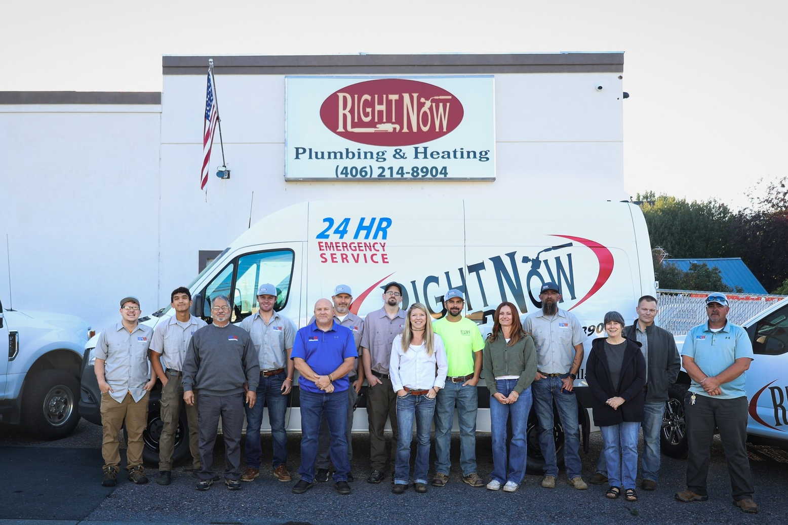 A group of people standing in front of a van that says right now plumbing and heating