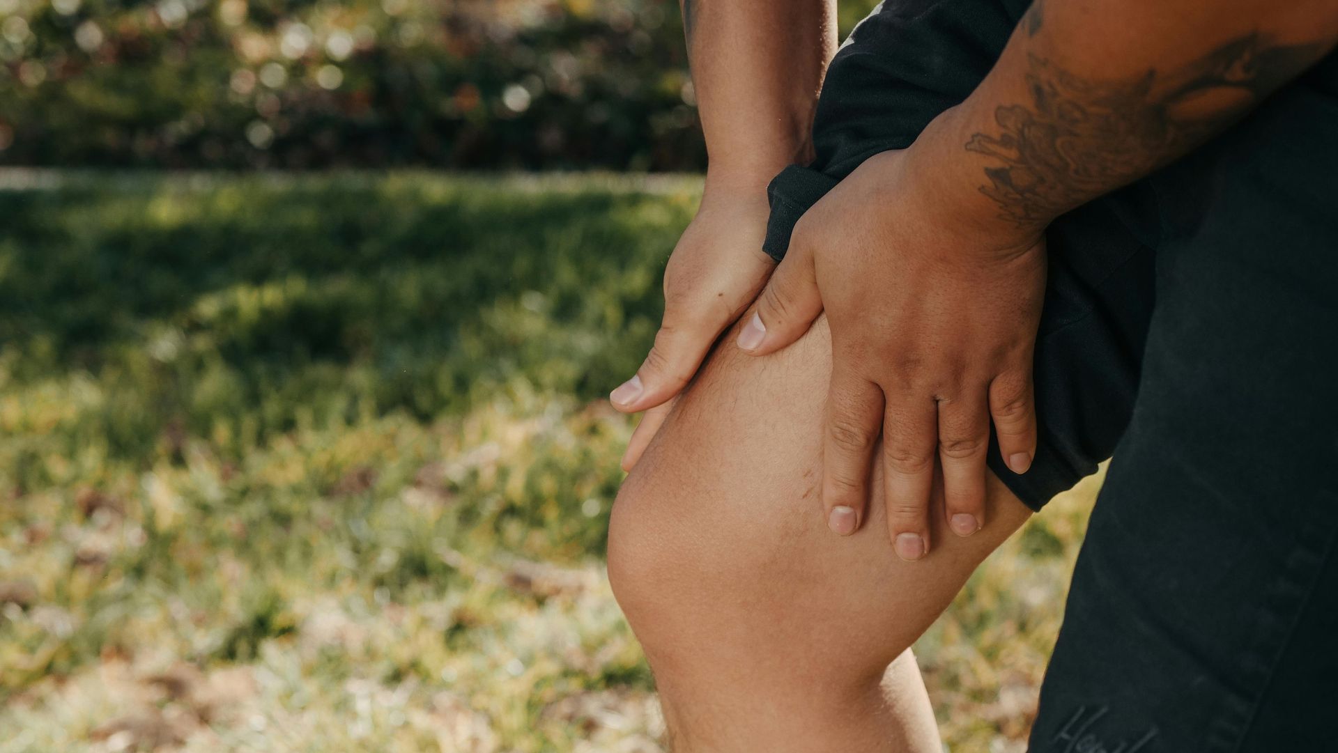 A soccer player is getting his knee examined by a doctor.