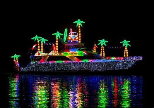 A boat decorated with christmas lights and palm trees is floating on top of a body of water.