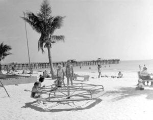 A black and white photo of people on a beach.