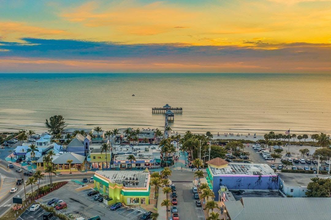 An aerial view of a city near the ocean at sunset.